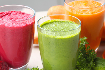 Fresh vegetable juices in glasses and ingredients, closeup