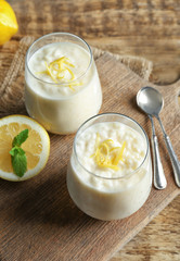 Obraz na płótnie Canvas Creamy rice pudding with lemon in glasses on wooden table