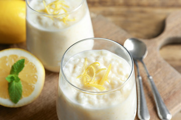Creamy rice pudding with lemon on table, closeup
