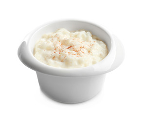 Creamy rice pudding with cinnamon powder in bowl on white background