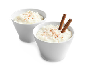 Creamy rice pudding with cinnamon powder in bowls on white background