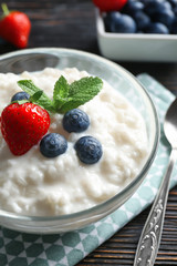 Creamy rice pudding with berries in bowl on table, closeup
