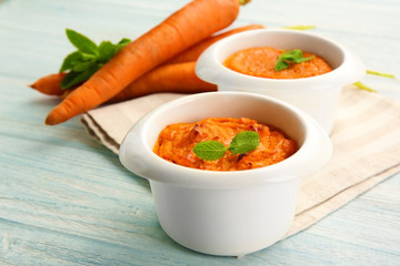 Ramekins with tasty carrot souffle on wooden table
