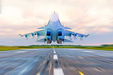 Military fighter jet flies at high speed over the taxiway at the airport