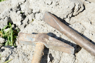 chisel and hammer at concrete block on construction site