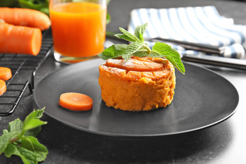 Plate with tasty carrot souffle on table
