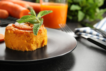 Plate with tasty carrot souffle on table, closeup