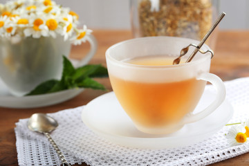 Cup of chamomile tea on wooden table