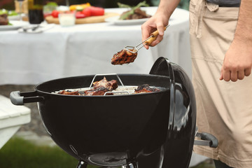 Man cooking ribs on barbecue grill