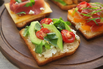 Tasty sandwiches on wooden board, closeup