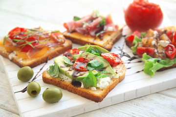 Fototapeta na wymiar Wooden board with tasty sandwiches on table