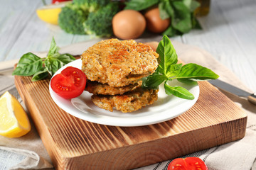 Broccoli pancakes served with cherry tomato and basil leaves on white plate