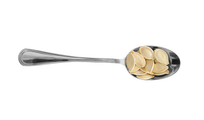 Pumpkin seeds in spoon on white background
