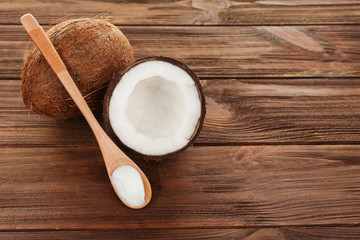 Spoon with coconut oil on wooden background