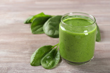 Jar of spinach smoothie on wooden table