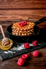 waffles with raspberries on wooden background