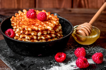 waffles with raspberries on wooden background