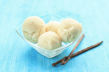 Bowl with delicious vanilla ice-cream balls on table