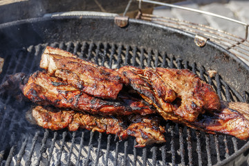 A piece of fried on the fire meat lies on the grill