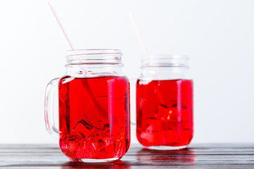 Wooden table top with two mason jars full of lemonade on light background