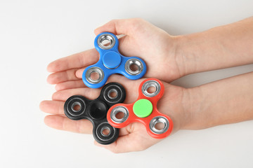 Man holding modern spinners on white background