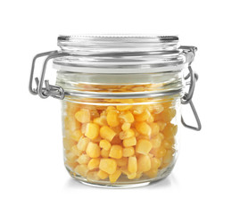 Jar with canned corn kernels on white background