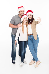 family in santa hats taking selfie