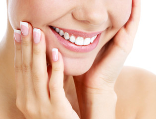 Obraz na płótnie Canvas Closeup shot of beautiful female smile and manicured fingers, white background.