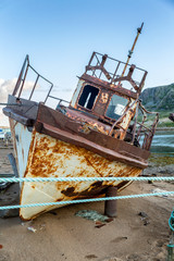 an abandoned rusty ship on a sandy beach
