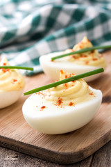 Stuffed eggs with mustard,mayo and paprika  on wooden table

