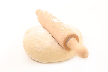 raw dough with rolling pin on white background