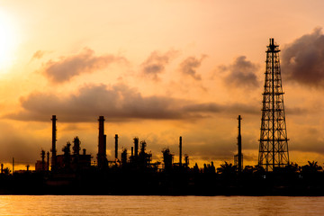Obraz premium Silhouette of Oil Refinery Industry Plant in Bangkok, Thailand with cloudy golden sunrise background. Conventional energy concept.