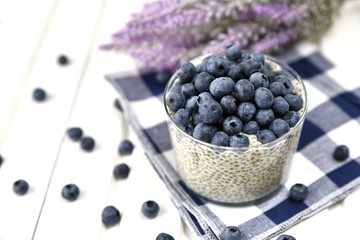 Полезный завтрак: пудинг чиа с черникой на салфетке, белый деревянный фон