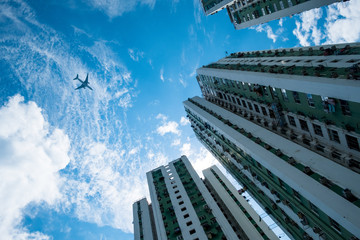 Fototapeta na wymiar Plane on arrival to Hong Kong airport flies over Allway Gardens public housing estate in Tsuen Wan, Hong Kong