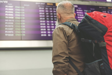 Unshaven pensioner watching at board with information