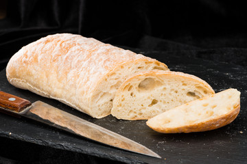 front view of fresh warm homemade bread on dark background
