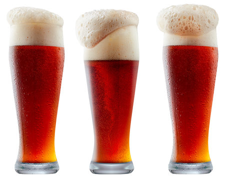 Mug of frosty dark red beer with foam isolated on a white background