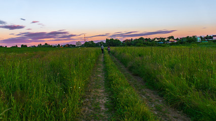 Obraz premium Couple walking on a dirt road in the evening time