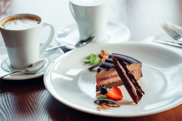 Caramel cake, mousse dessert on a plate. Grey stone background.