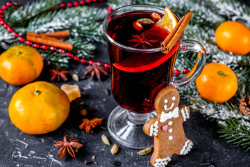 Fototapeta na wymiar Christmas mulled wine with spices in cup on dark background