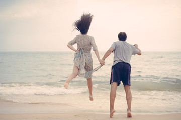Lovely couple having fun on the beach outdoors background. Back view of healthy people, excitement and amazement emotional freedom leisure. Travel vacation attractive enjoyment lifestyle.