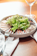 assorted meat on white plate on wood background