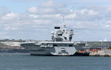 Portsmouth England UK.Royal Navy Dockyard with aircraft carrier HMS Queen Elizabeth alongside the Princess Royal jetty. August 2017.
