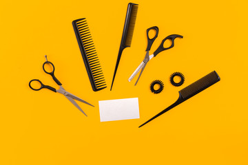 Hairdresser tools on yellow background with copy space, top view, flat lay.