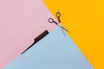 Barber set with comb and scissors on the color pink, yellow, blue paper background