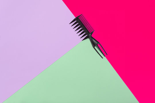 Comb on the color pink,lilac, green paper background. Top view