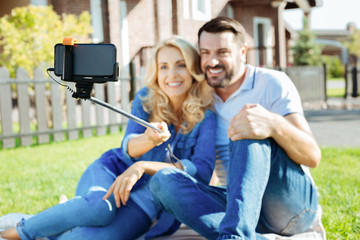 Naklejka premium Lovely couple using selfie stick on picnic
