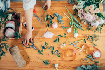 Small business. Flowers delivery top view. Florists creating order, making rose bouquet in flower shop.