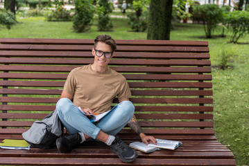 Happy young man studying outdoors