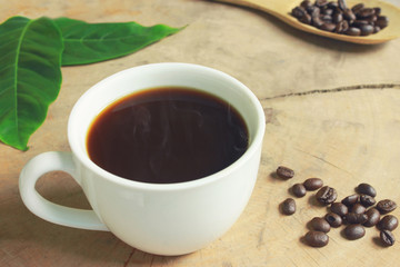 Hot Coffee cup with Coffee beans on  wooden background